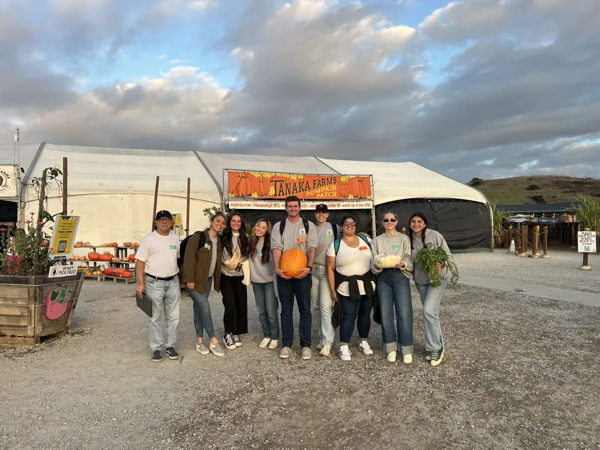 A group of people standing in front of an outdoor tent.