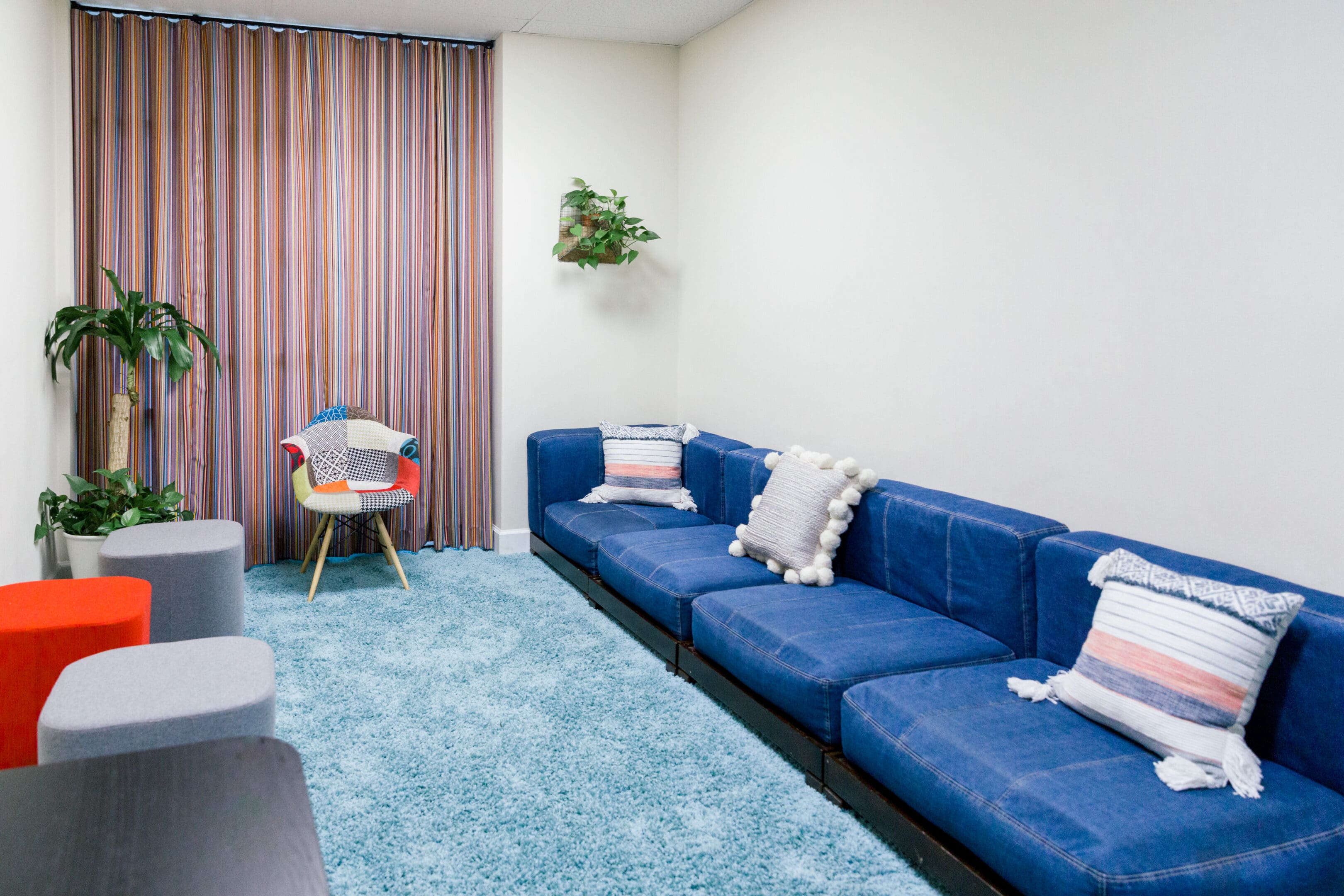 A living room with blue couches and a chair