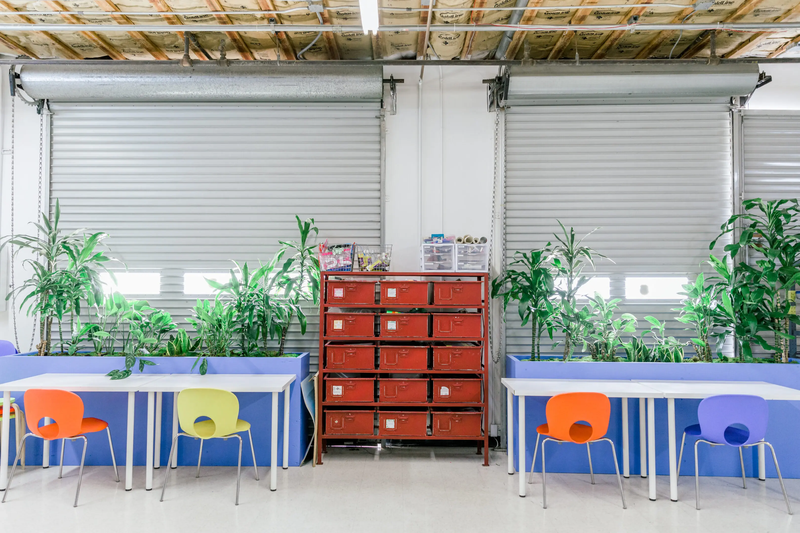 A room with two tables and plants in it